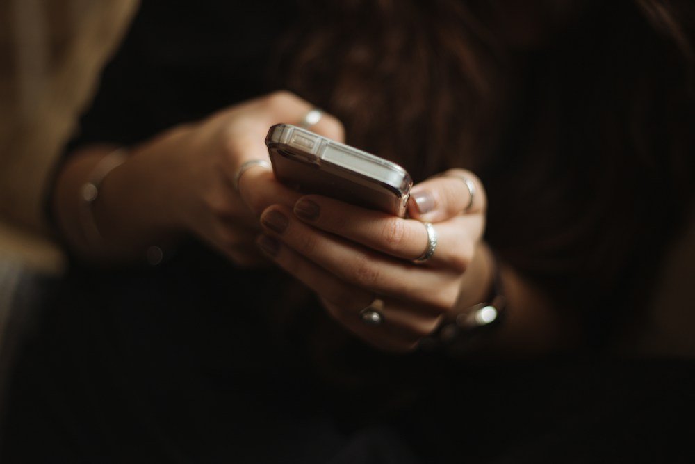 A person using a smartphone in a relaxed everyday setting
