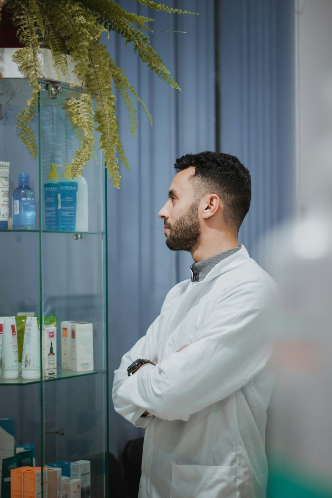 A pharmacist standing beside shelves in a neighbourhood pharmacy